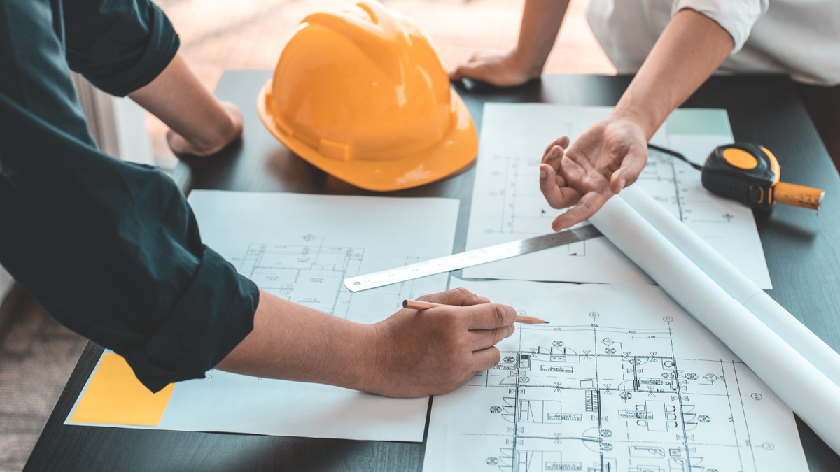 Profesionales revisando planos y documentación de un proyecto industrial