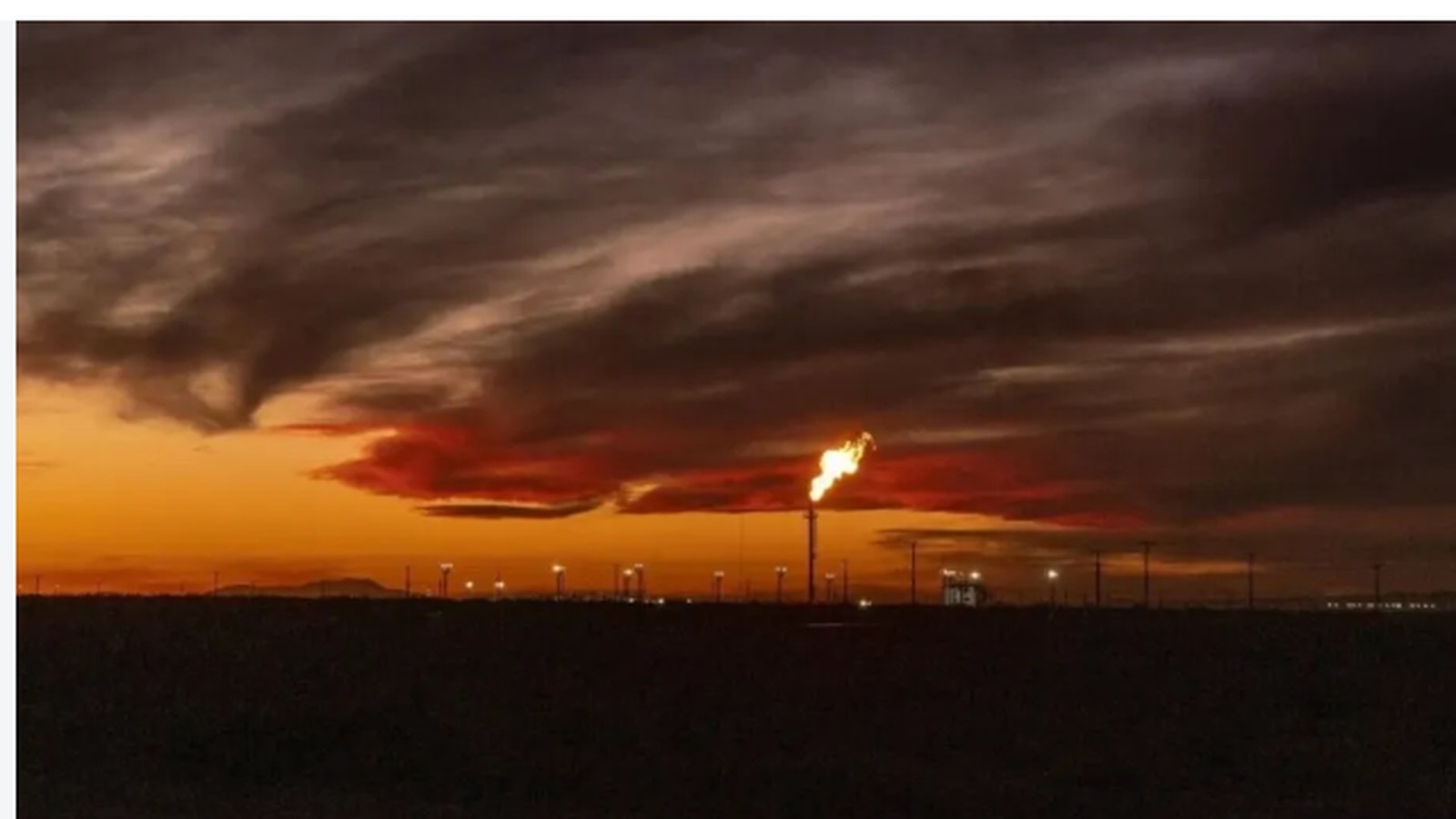 Antorcha de gas al atardecer en un yacimiento de Vaca Muerta