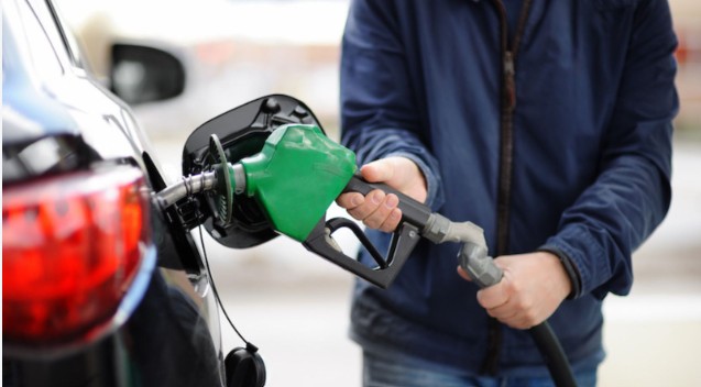Persona cargando combustible en un surtidor