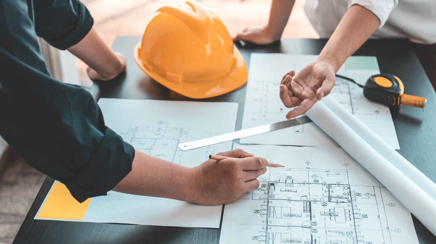 Planos y documentación de un proyecto de infraestructura sobre una mesa de trabajo